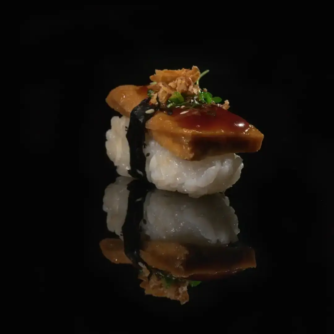 Nigiri satuan terpantul di kaca hitam