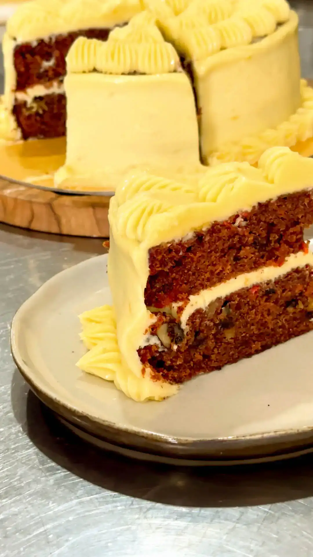 Carrot cake dengan frosting krim keju, satu potong sudah diiris