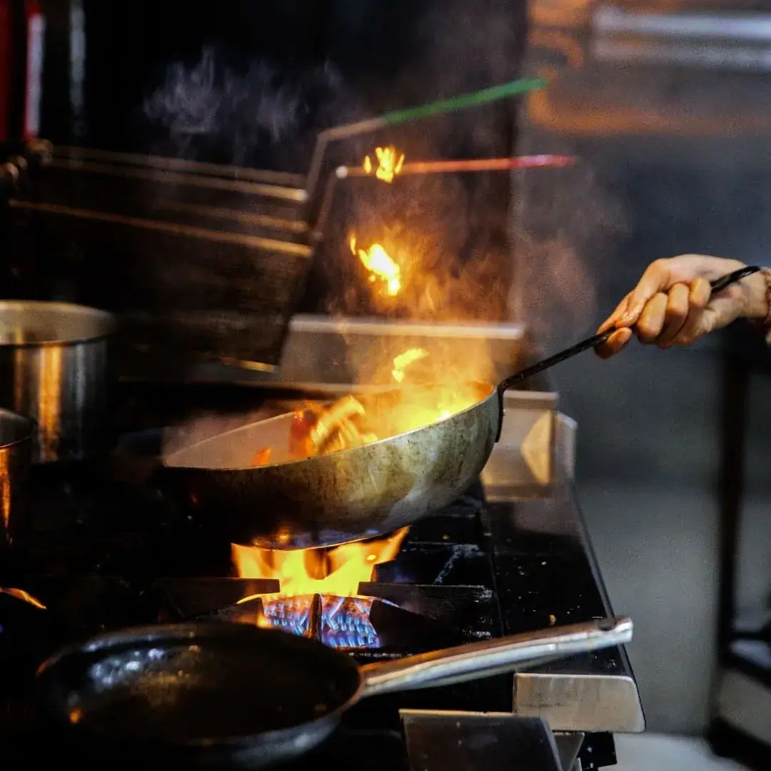 Api menyembur dari wajan di dapur terbuka