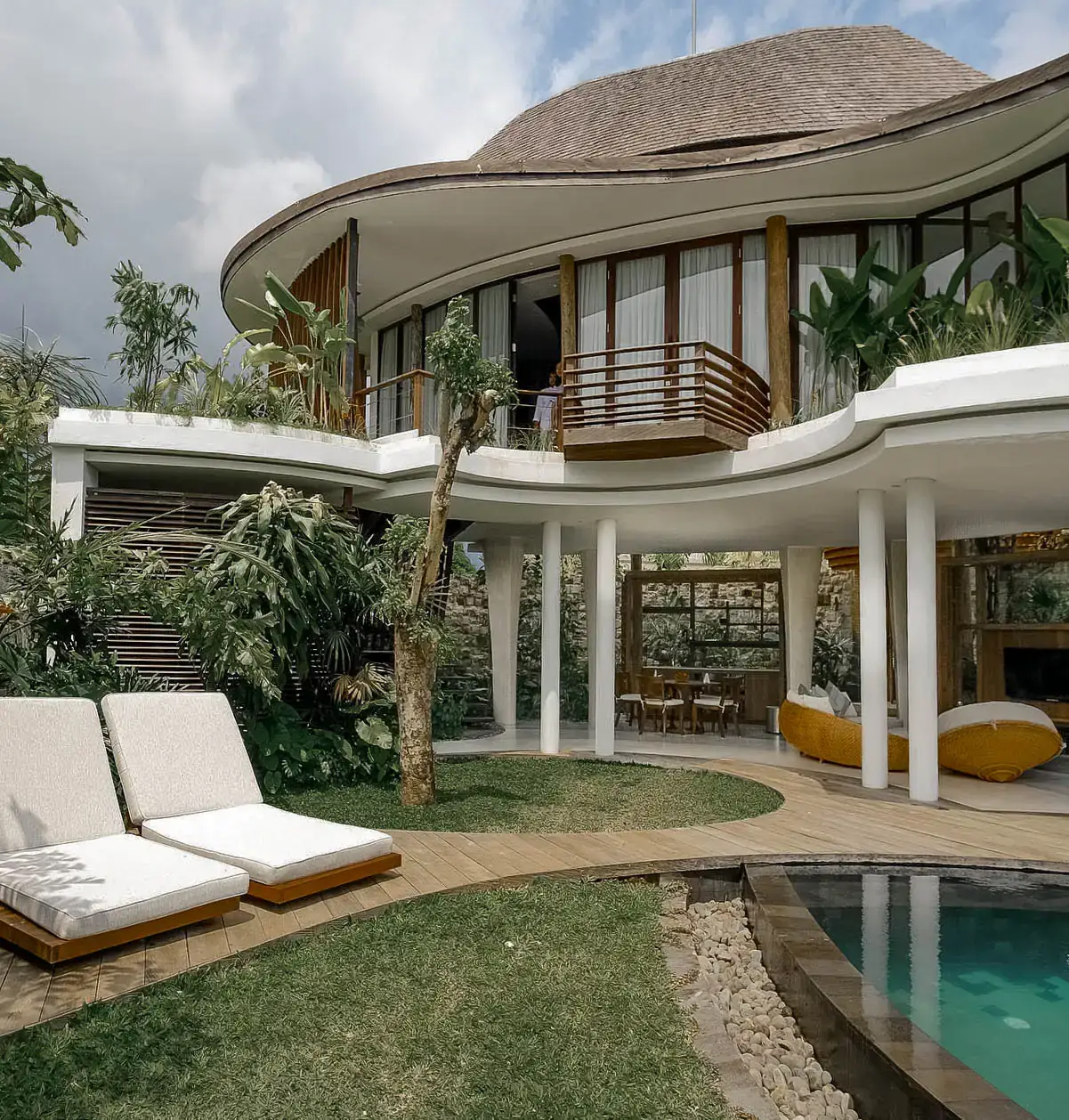 Villa dari taman — atap jerami melengkung di atas kolam