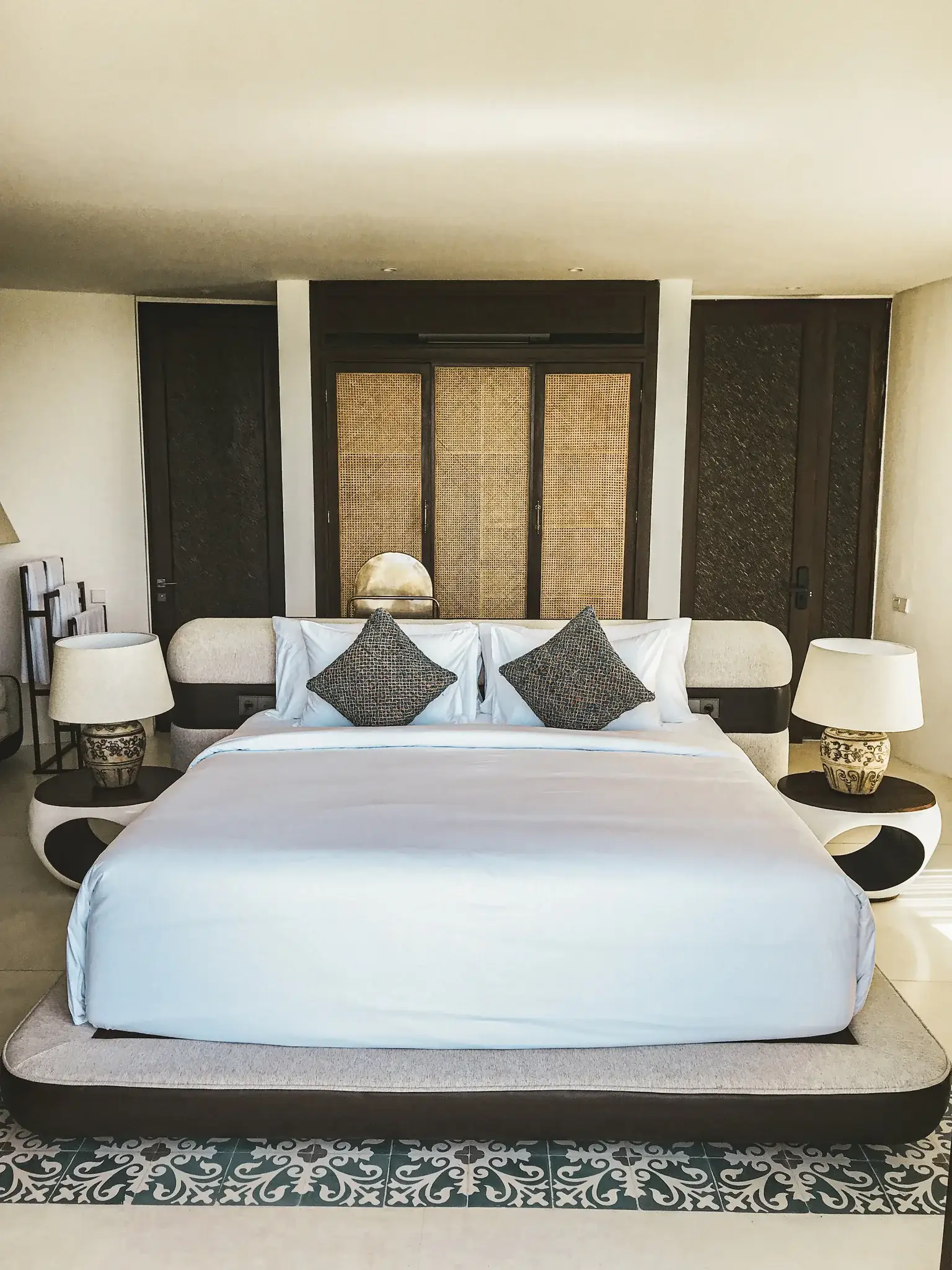 Kamar kayu gelap dengan linen putih dan lantai bermotif