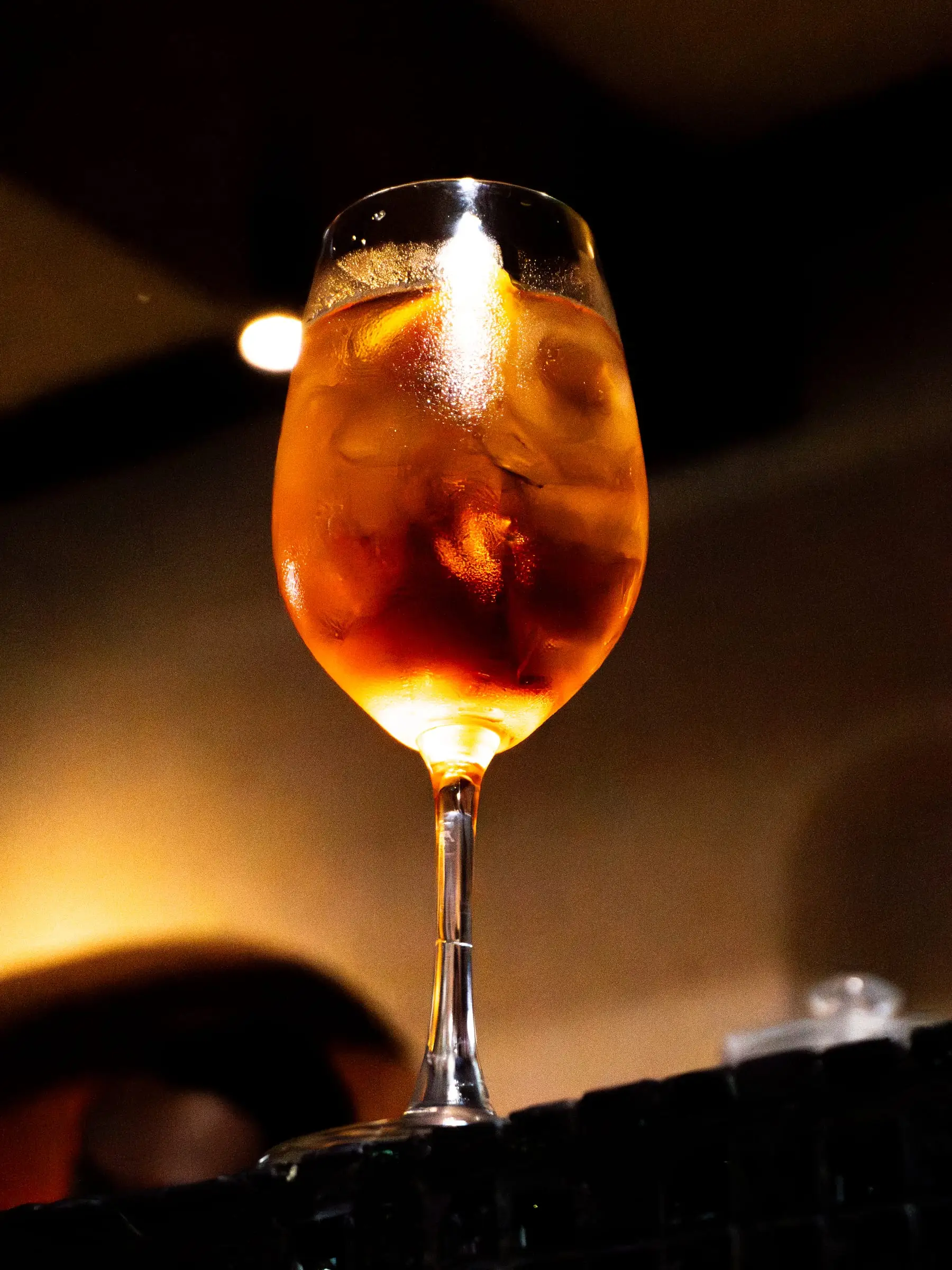 Spritz jeruk dalam gelas anggur dengan latar gelap