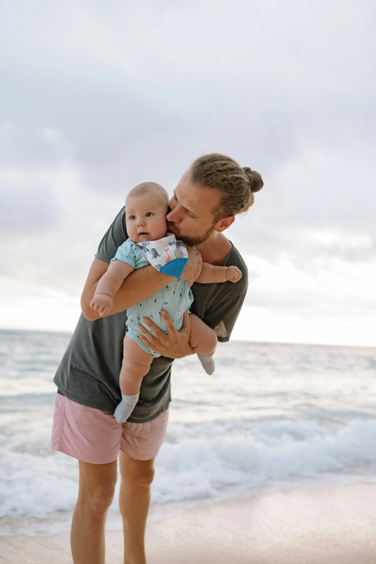 Ayah mencium bayi di tepi laut