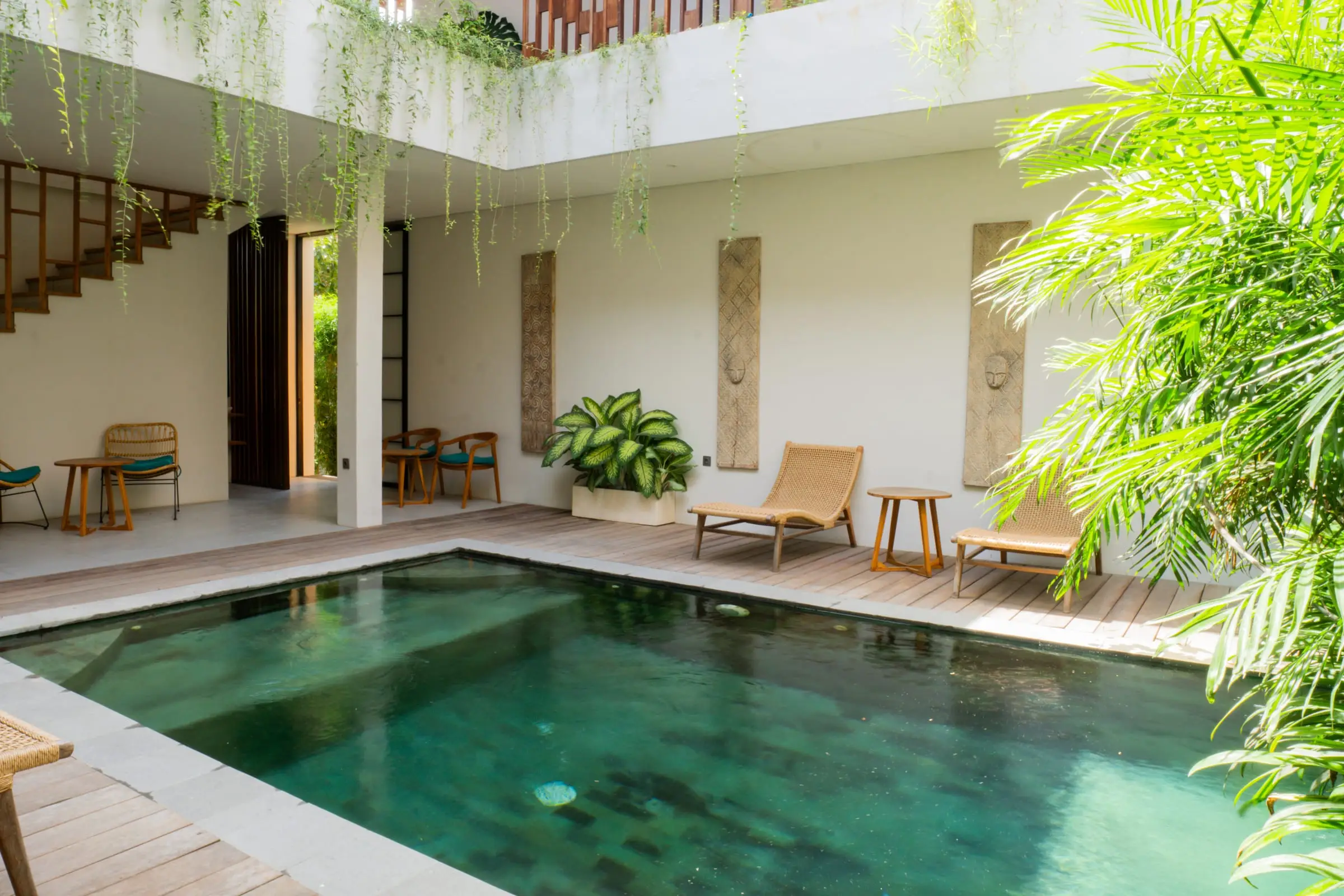 Kolam renang di tengah villa dengan tanaman gantung